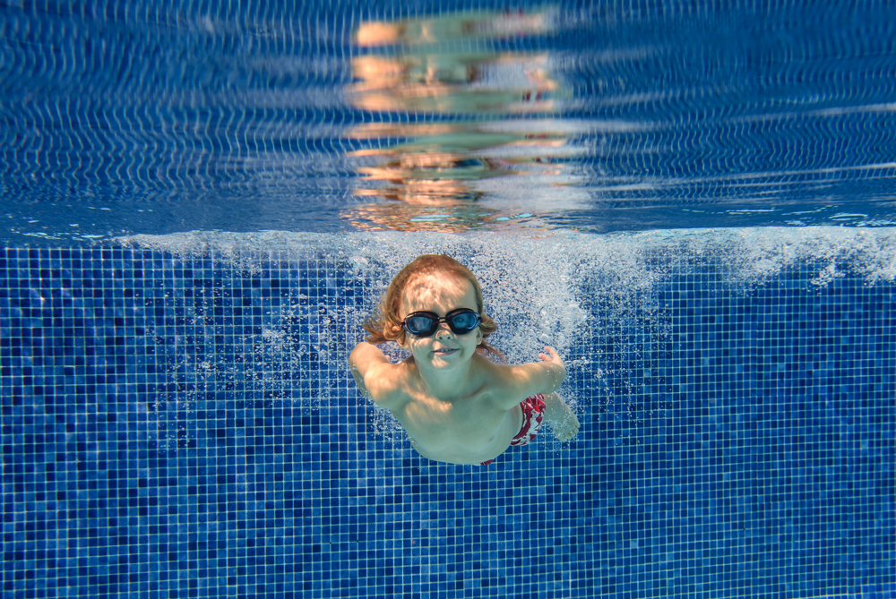 menino nadando em uma piscina - fibra ou alvenaria